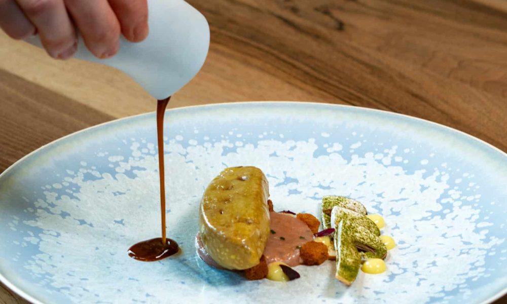 Foie gras poché au consommé de langoustines, tartare de langoustines et champignons bruns à cru