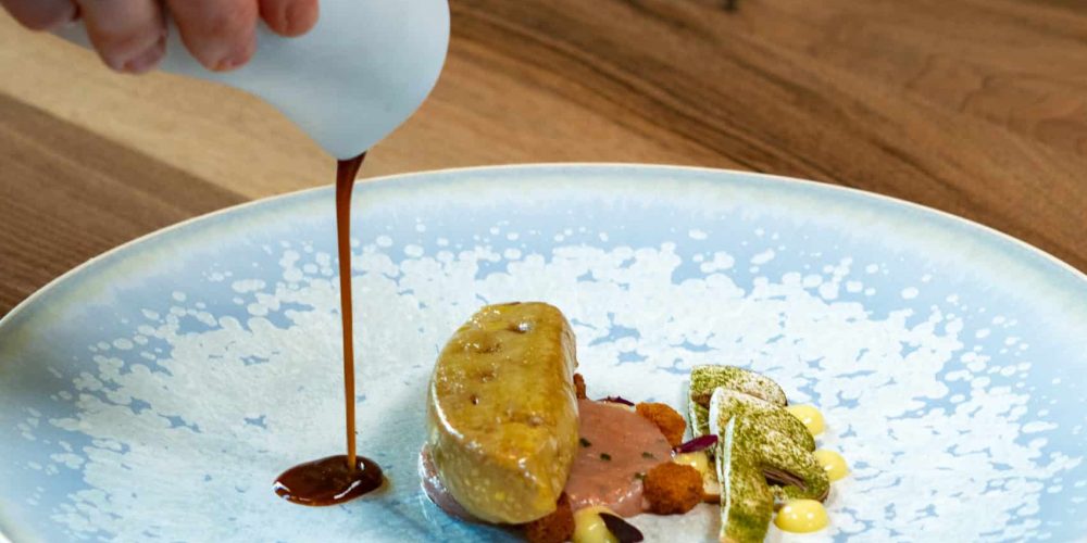 Foie gras poché au consommé de langoustines, tartare de langoustines et champignons bruns à cru