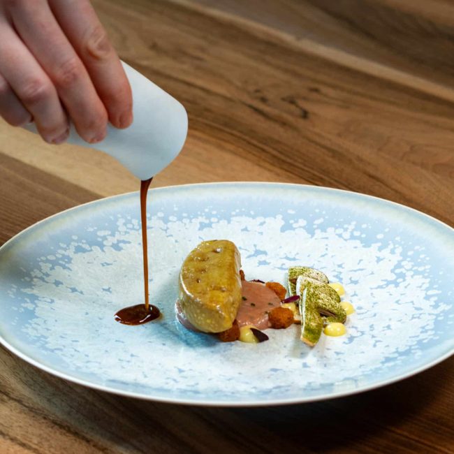 Foie gras poché au consommé de langoustines, tartare de langoustines et champignons bruns à cru