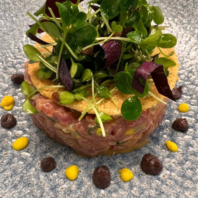 Tartare terre et mer sur une galette de socca, mélange de pousses à l&rsquo;huile de noisette