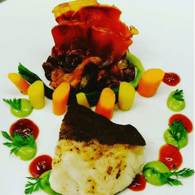 Dos de cabillaud poêlé aux girolles, carottes fanes et coulis de petit-pois